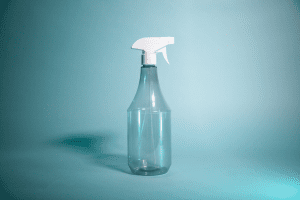 Transparente Keulenflasche von EPROPLAST mit weißem Sprühaufsatz vor grünem HIntergrund