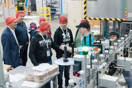 Auszubildende der EPROPLAST GmbH führen Besucher und interessierte Jugendliche bei der AZUBI-Tour durch die Fertigung der EPROPLAST GmbH und erläutern die Herstellung von PET-Kunststoff-Flaschen.